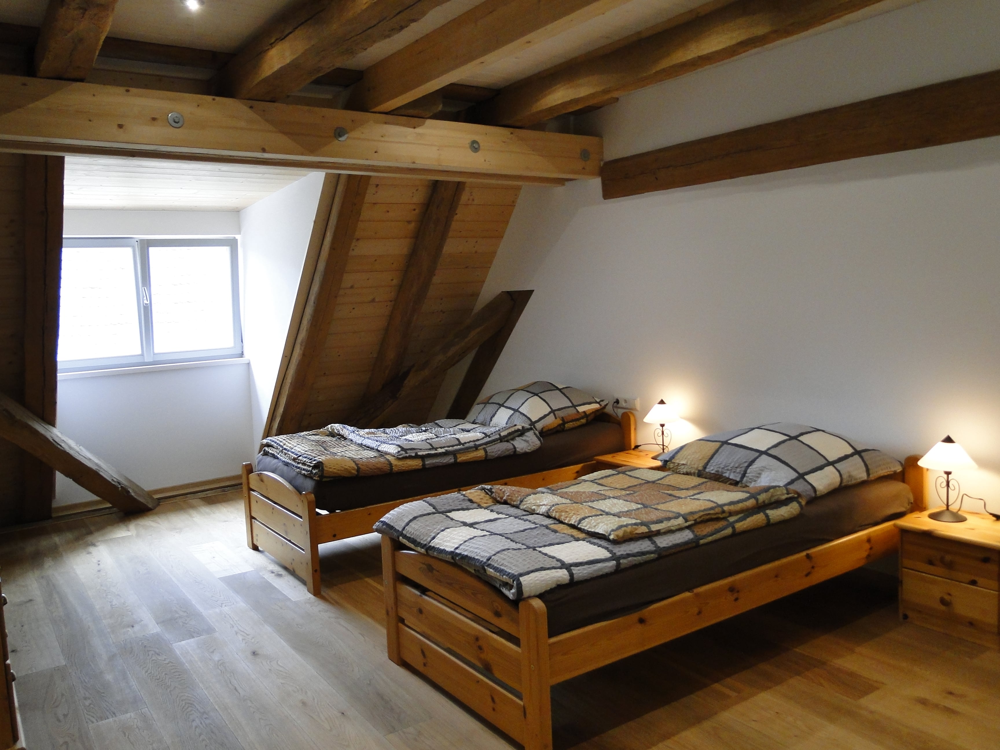 Zwei Einzelbetten mit Nachtischen an einer Wand